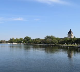 A shot of Wascana Lake, with the still waters of the lake and the Legislative Building visible at a distance.
