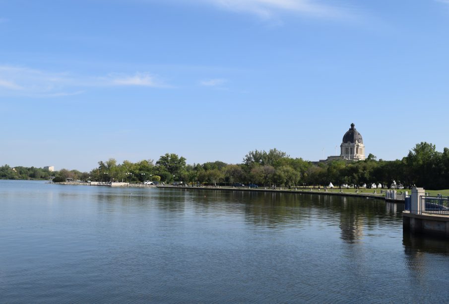 A shot of Wascana Lake, with the still waters of the lake and the Legislative Building visible at a distance.