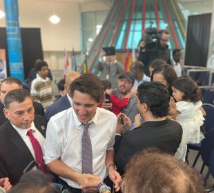 Justin Trudeau is swarmed by members of the town council as he makes his exit. 