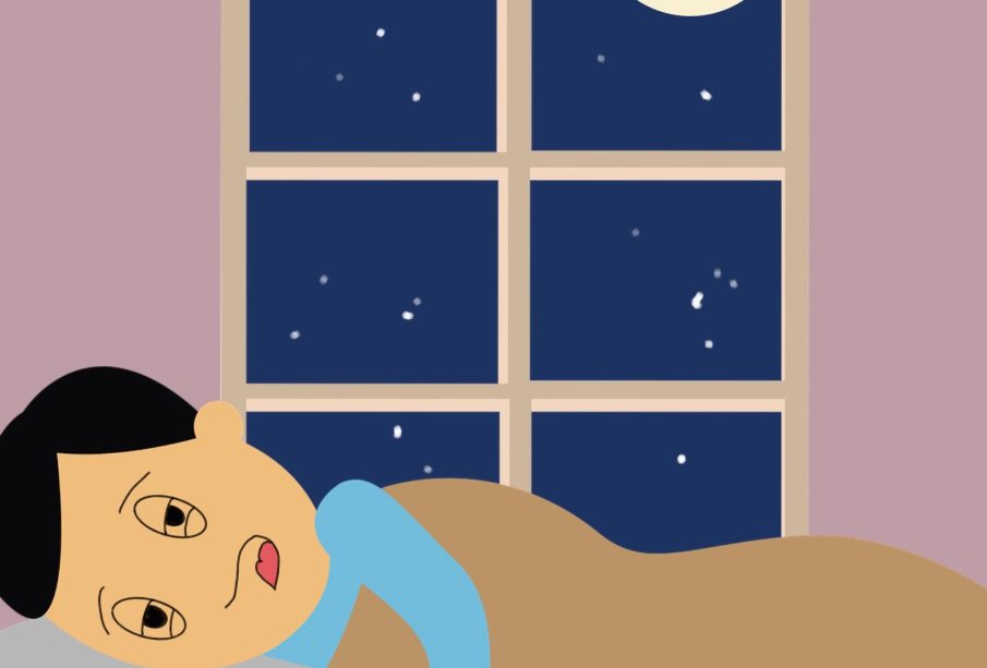 A person lying in bed, visibly tired but scrolling away on their phone.