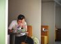 Someone sits in a booth with their head in their hand, staring at their laptop with frustration.