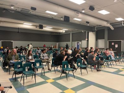 Students eat pizza while they wait for URSU to fix the microphone.