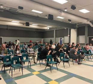 Students eat pizza while they wait for URSU to fix the microphone.
