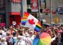 A photo from a pride parade, with a flag merging the flag of Canada and the pride flag in the forefront