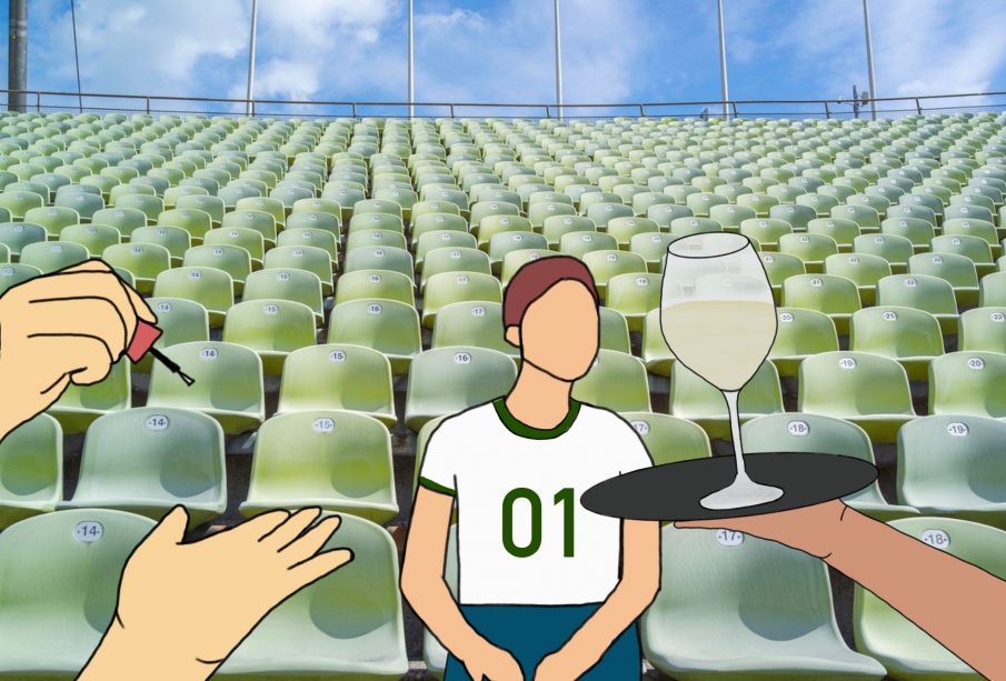 A spectator sits in a football stadium. Drinks are being served to them while someone does their nails.