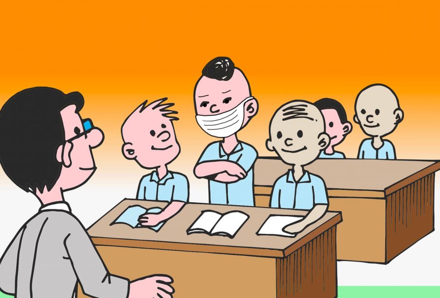 In a classroom, the only student wearing a mask stands in the first row.
