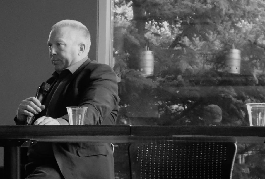 Gene Makowsky sits beside Andrew Scheer’s vacated chair at URPolis’ Meet Your Representatives event.
