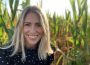 A photo of Megz Reynolds standing in the backdrop of a farm.