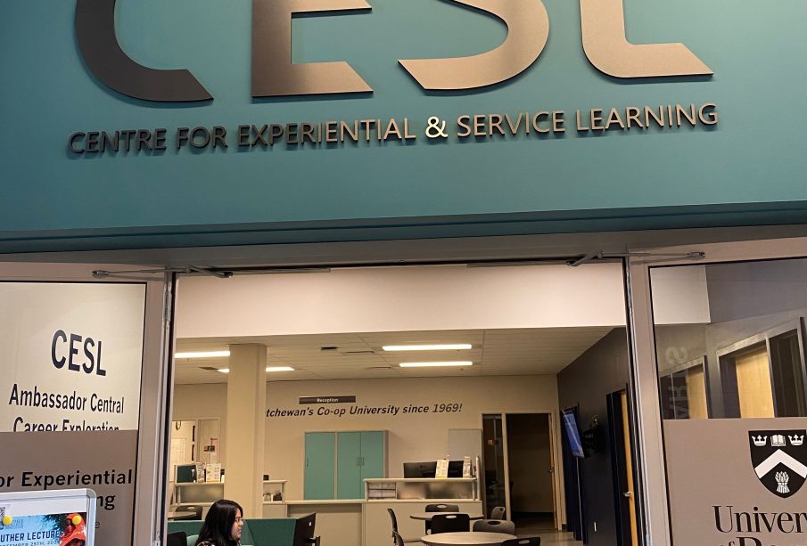 A door opens into an office space with the words “Centre for Experiential and Service Learning” overhead.
