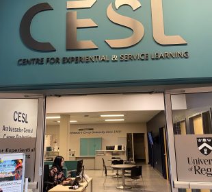 A door opens into an office space with the words “Centre for Experiential and Service Learning” overhead.
