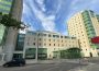 A photo depicts a University of Regina student residence against a dramatic blue, cloud-streaked sky.