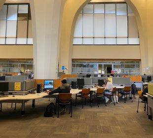 The ground floor of the Archer library, from the entrance. Students are studying at some of the computers.