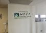 A white wall with the phrase “Welcome to HOPE Learning Centre” in black words with the phrase “Helping Others thru Peer Education” beneath it.