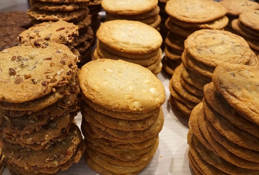 Many stacks of cookies that look like they contain nuts and chocolate chips.