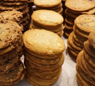 Many stacks of cookies that look like they contain nuts and chocolate chips.