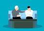A young adult is sitting on a couch with a counsellor, who has their hand on their shoulder supportively.