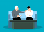 A young adult is sitting on a couch with a counsellor, who has their hand on their shoulder supportively.