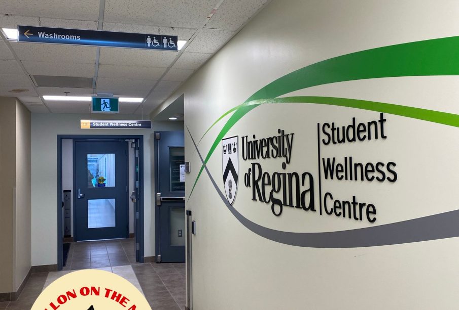 A photo of a wall with the words “University of Regina Student Wellness Centre” on it. 