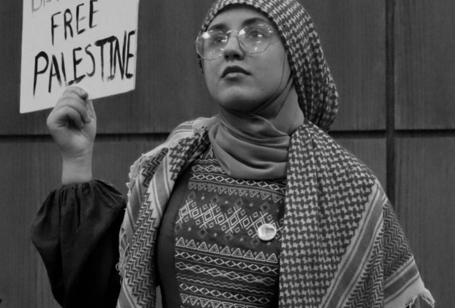 A young woman holds up a protest sign on behalf of civilians in Gaza.