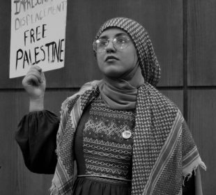 A young woman holds up a protest sign on behalf of civilians in Gaza.