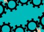 Several different hands juggle and fit together gears like those found in clockworks.
