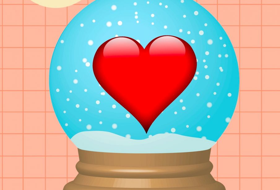 A heart sits in the middle of a snow globe.