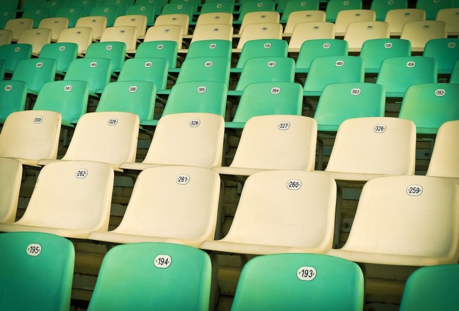Rows of green and yellow sports stadium seats.