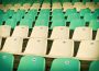 Rows of green and yellow sports stadium seats.