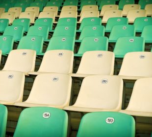 Rows of green and yellow sports stadium seats.