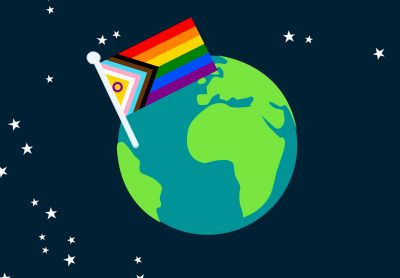 In the middle of a starry galaxy, the globe of Earth is suspended, and features a trans-inclusive pride flag stuck into the oceans.