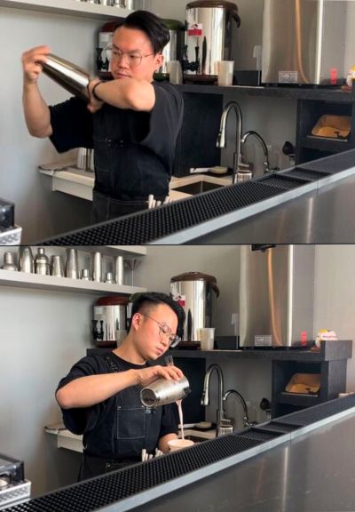 This image shows a person standing behind a counter. The kitchen is industrial with clean metal, and the person is wearing glasses and a kitchen apron. The top image shows the person shaking bubble tea in a metal cup, and the bottom image shows them pouring it into a glass.