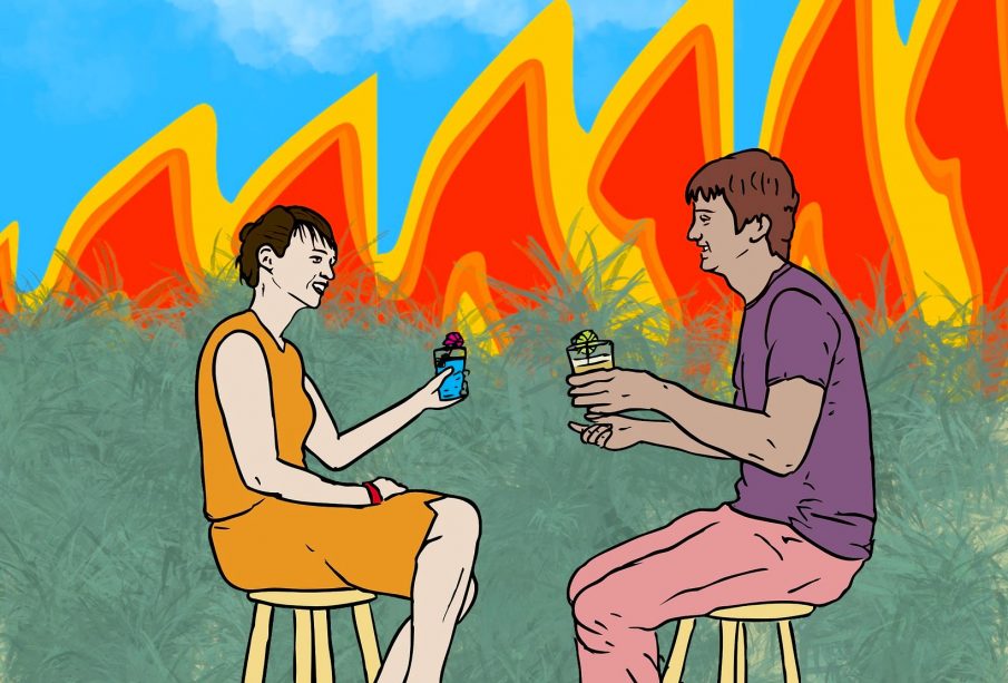 Two people sitting on chairs enjoying a drink, while there is fire in the background.