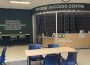 A banner of light-coloured text on a dark background titled Student Success Centre is above a reception area in an open room surrounded by study tables and blue chairs.