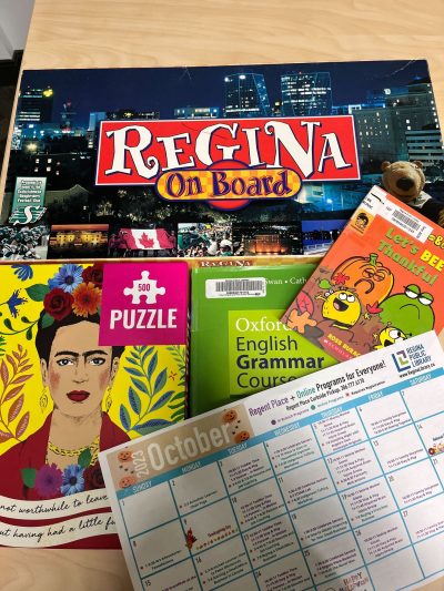 Board games, books, puzzles, and an activity schedule on a calendar page.