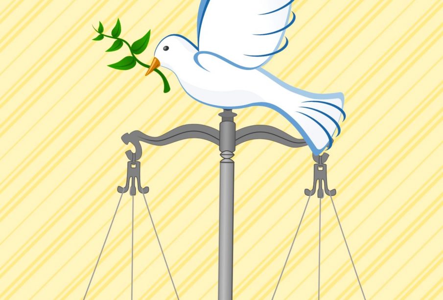 A dove with a sprig of greenery in its beak sits atop a weigh scale. 
