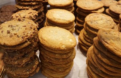 Many stacks of cookies that look like they contain nuts and chocolate chips.