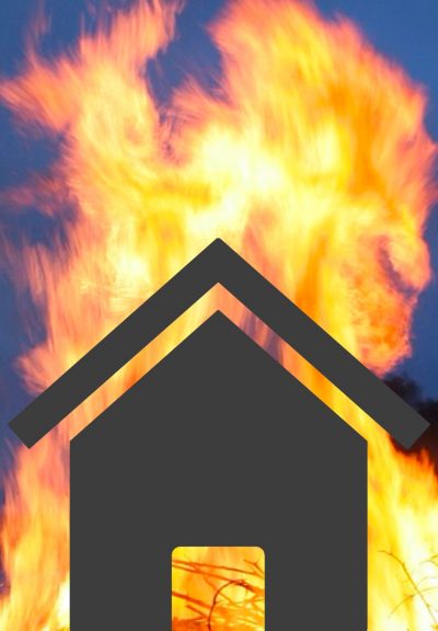The black outline of a home is backlit by destructive flames.
